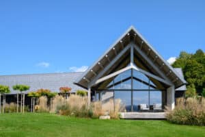Modernes Haus mit Satteldach, Holz-Terrassenpodest, großer Fixverglasung und Terrassenschiebetüren von M SORA.