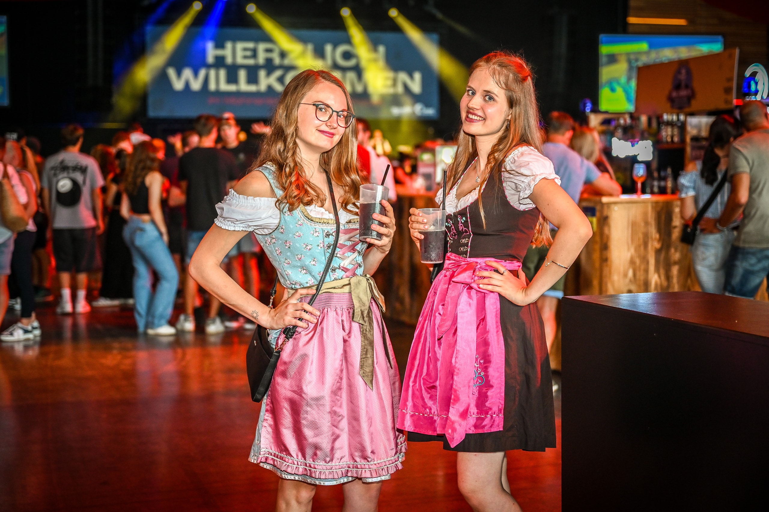 Zwei Frauen in Dirndl-Kleidern posieren auf einer Tanzfläche bei der Herbstmesse Dornbirn.