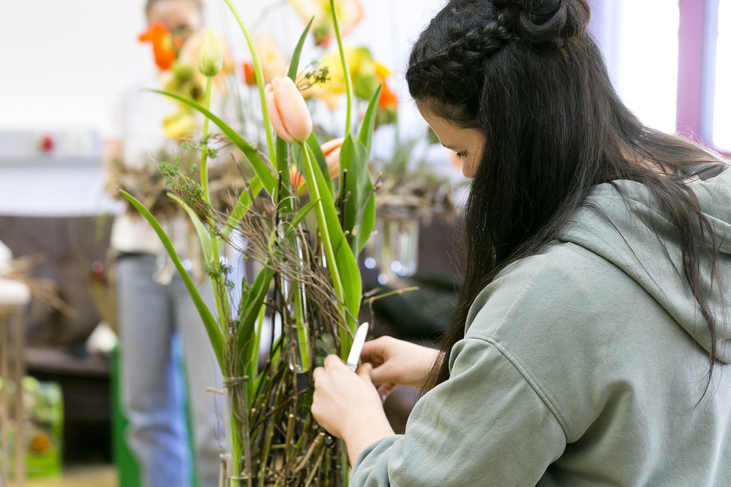 Eine Floristin bindet einen frischen Blumenstrauß und gewährt den Besuchern der Frühjahrs- und Freizeitmesse „SCHAU!“ im Messequartier Dornbirn Einblicke in Handwerk, Materialien und Gestaltung moderner Blumenkreationen bereitgestellt von der Wirtschaftskammer Vorarlberg.