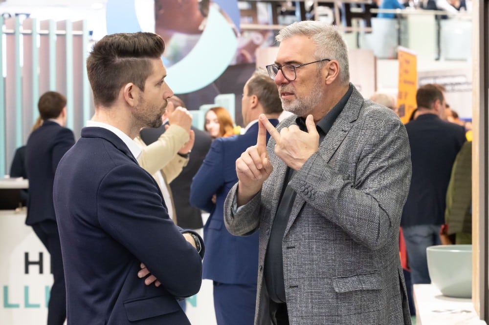Zwei Herren, verwickelt in ein Fachgespräch, auf der WEBUILD Energiesparmesse Wels.