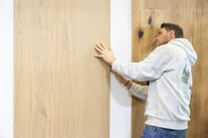 Ein Mann begutachtet verschiedene Laminatböden bzw. Holzmuster mit unterschiedlichen Oberflächen bei der Energiesparmesse Wels.