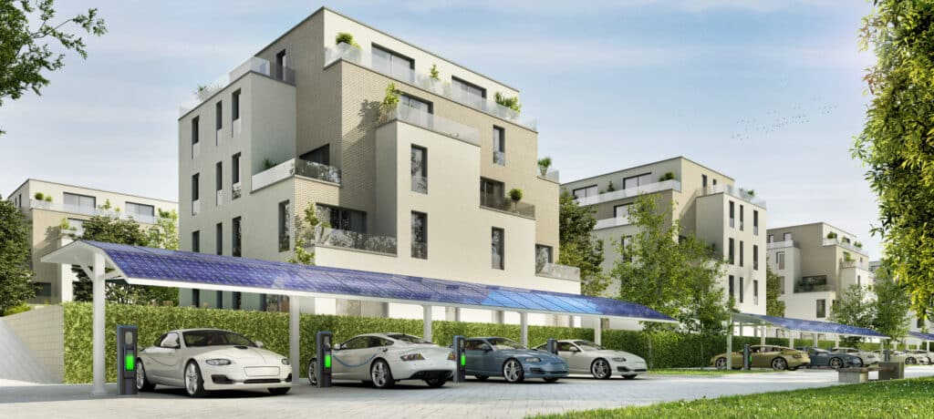 Ein Wohnblock mit Wallboxen und Solarüberdachung für E‑Mobilität, präsentiert bei den E-Car-Days der WEBUILD Energiesparmesse Wels.