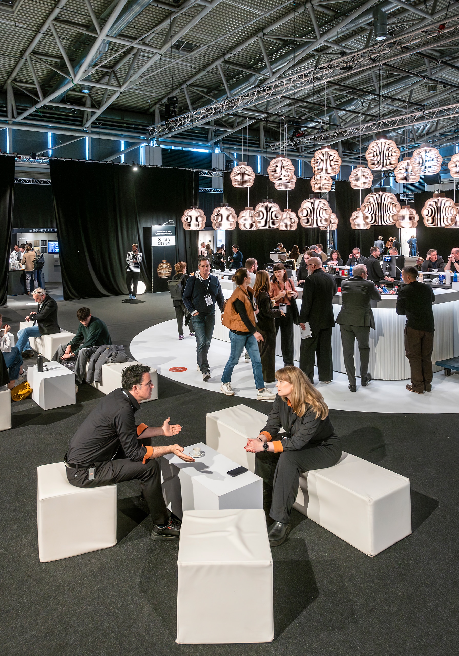 ARCHITECT@WORK Messe Wien 2026 zeigt Besucher in der Lounge und an der Bar bei Gesprächen.