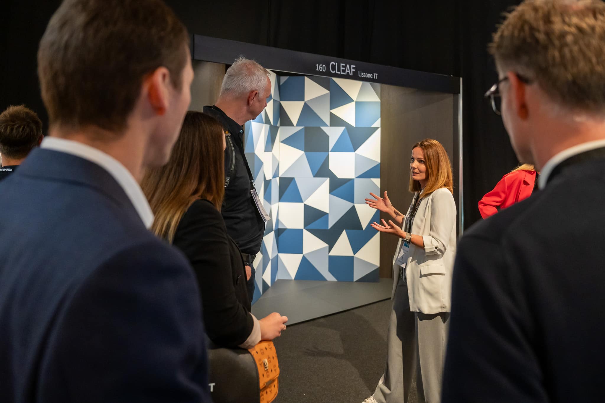 ARCHITECT@WORK Messe Wien 2026 zeigt eine Ausstellerin, die Besuchern ihr Produkt erklärt.