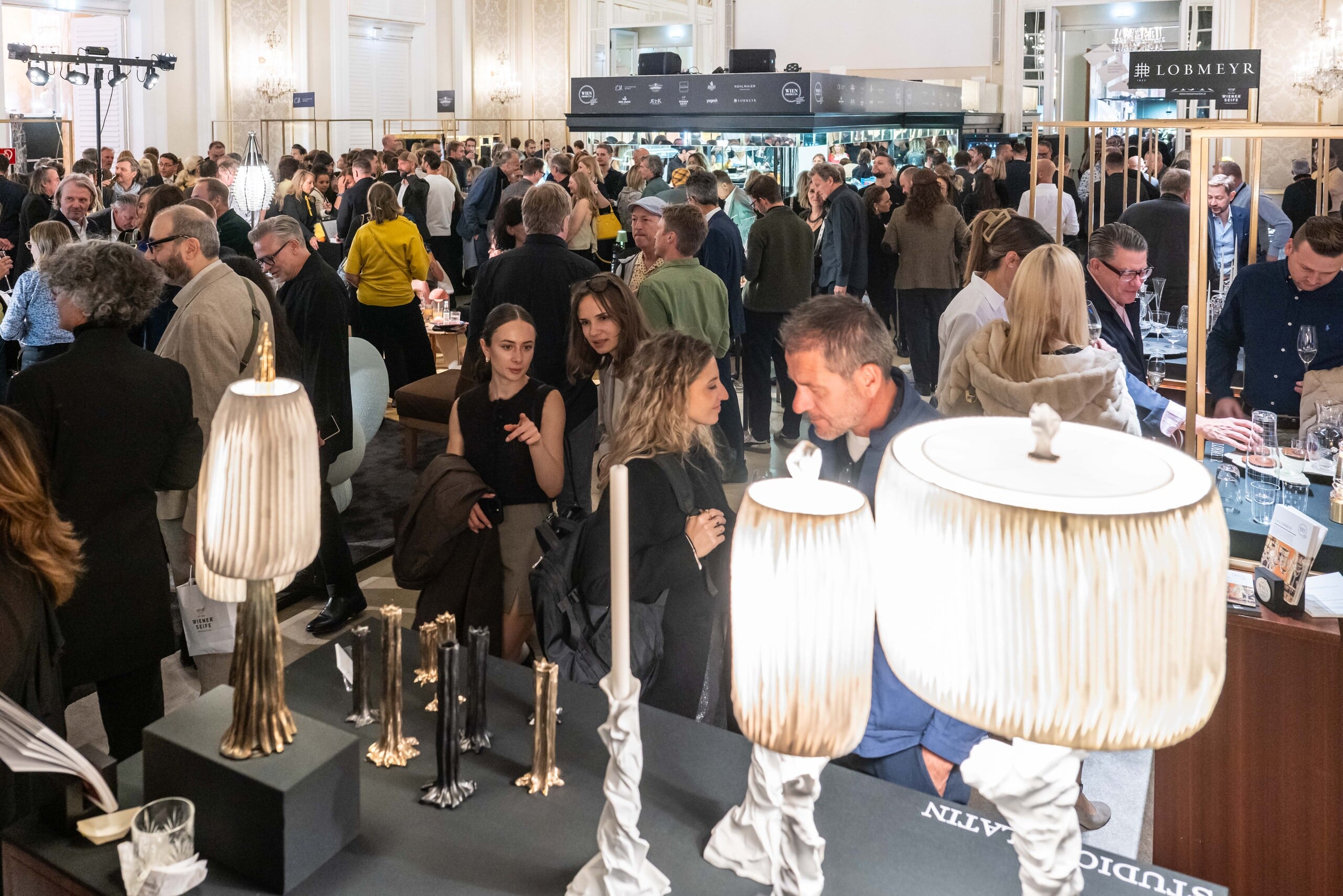 Besucher der Messe Design District 1010 entdecken stilvolle Interieurs mit hochwertigen Lampen und ausgewählten Wohnaccessoires.