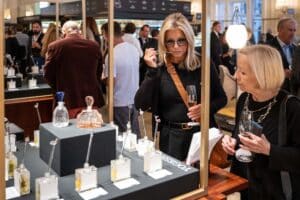 Besucher der Messe Design District 1010 entdecken eine stilvolle Präsentation mit Parfüms und verschiedenen Duftproben.