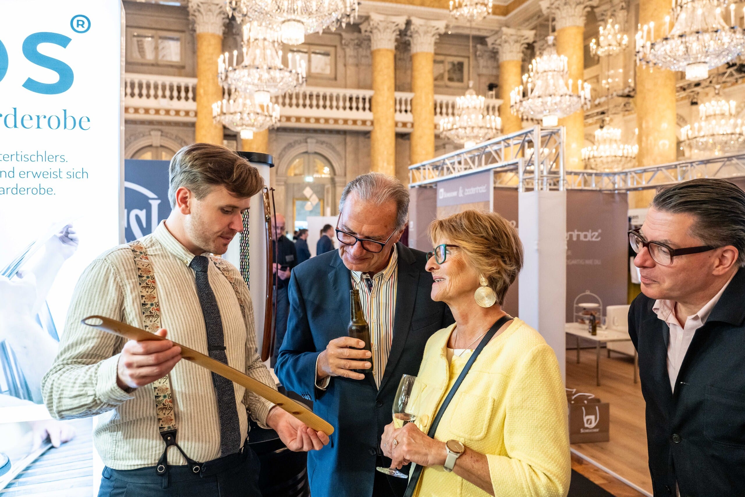 Besucher der Messe Design District 1010 verfolgen eine anschauliche Produktvorführung mit traditionellem Handwerk und hochwertigen Materialien.