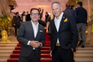 Peter Syrch posiert mit einem Kollegen am repräsentativen Treppenaufgang der Wiener Hofburg bei der Messe Design District 1010.