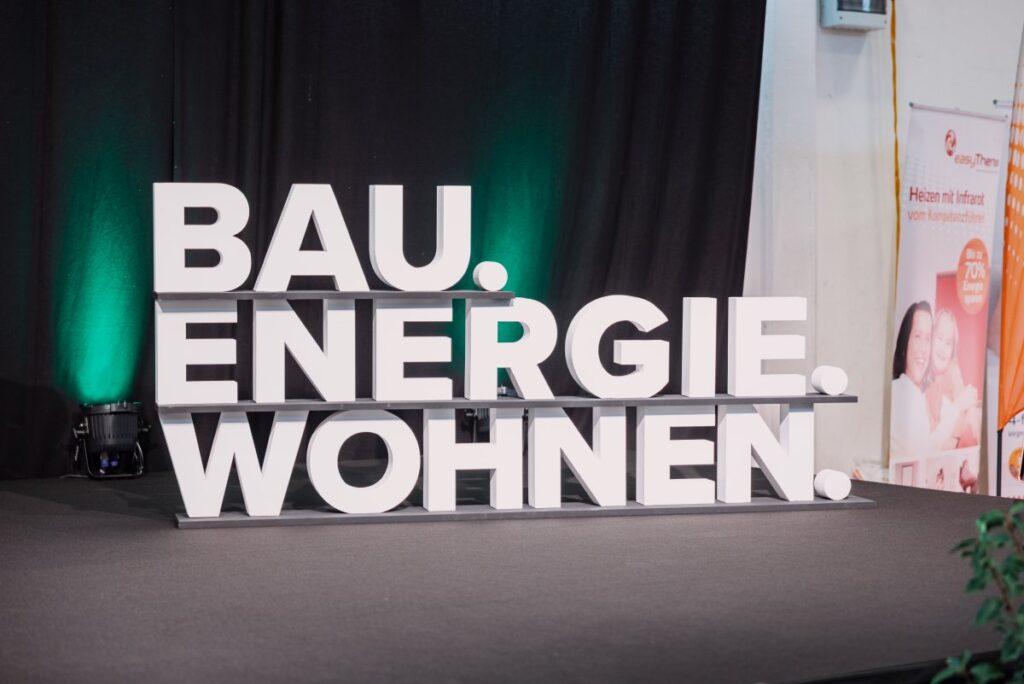 Der Schriftzug der Messe Bau.Energie.Wohnen auf der Bühne in Wieselburg – als Blickfang im Rahmen der Messe rund um Bauen, Energieeffizienz und modernes Wohnen.
