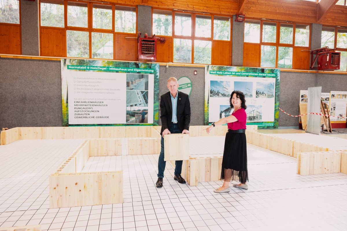 Besucherinnen und Besucher erkunden einen begehbaren Hausplan am Messestand von Bausatzhaus und erhalten Einblicke in die Planung und Gestaltung des eigenen Traumhauses auf der Messe Bau.Energie.Wohnen in Wieselburg.
