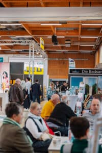 Besucherinnen und Besucher in der Messehalle mit Ausstellung rund um Badezimmer auf der Bau.Energie.Wohnen in Wieselburg.