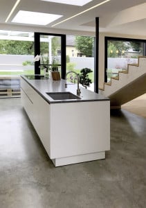 Moderne Inselküche mit freitragender Treppe im Hintergrund auf einer Fußbodendämmung von thermotec®.
