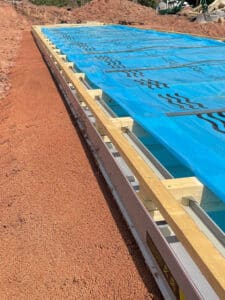 Eine Poolumrandung mit aufgeschütteter Dämmung und Ablaufrinne von thermotec®.