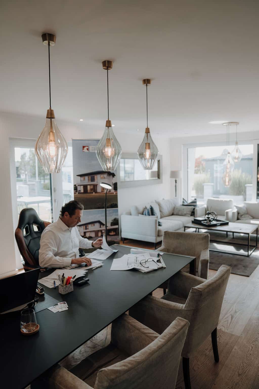 Im offenen Wohnraum eines Hauses des Musterhausparks werden am Esstisch Baupläne studiert.