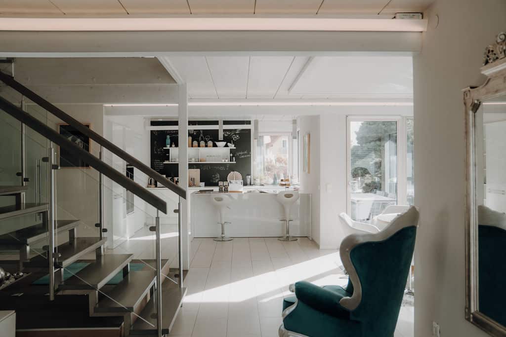 Offener Wohnraum eines Hauses mit Blick in die offene Wohnküche mit Bar im Musterhauspark.