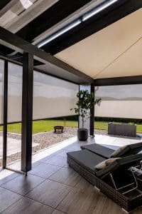 Newo Sonnen- und Insektenschutz zeigt eine überdachte Terrasse, die mit Textilscreens beschattet wird.