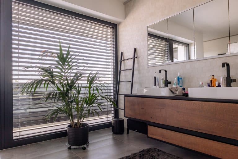 Newo Sonnen- und Insektenschutz zeigt ein Badezimmer, mit Blick durch ein Fenster mit Raffstores.