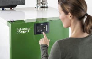 Eine Frau bei der Bedienung des Touchpanels einer Pellematic Compact von ÖkoFEN.