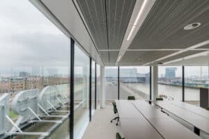 Opple Lighting zeigt einen großen Besprechungsraum mit großen Fensterfronten und in der Akustikdecke integrierte stabförmiger Leuchten.
