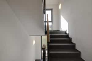 Opple Lighting zeigt eine Treppenhaus mit an der Wand montierten runden Leuchten.