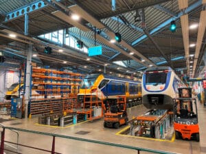 Opple Lighting zeigt eine große Halle für Eisenbahnwagons mit vielen auf Trägerschienen montierten ringförmigen Leuchten.