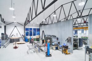 Opple Lighting zeigt eine große Werkstatt mit vielen an der Decke hängenden ringförmigen Leuchten.