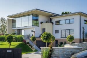 Villa mit Flachdach, Garage, überdachter Terrasse und einem elektrischen Einfahrtstor von Planungsbüro Schaufler.