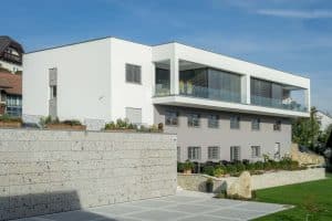 Villa mit Flachdach mit Rund-um-Balkon, Glasgeländer und überdachter Terrasse von Planungsbüro Schaufler.