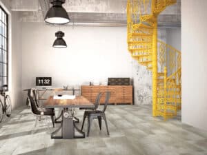 Ein modernes Industrial-Loft mit Bodenbelag in authentischer Steinfliesen-Optik, schmiedeeiserner Wendeltreppe und markanten gelben Akzenten – von Project Floors.
