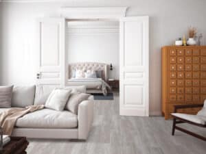 Ein klassischer Altbau mit renoviertem Wohn- und Schlafbereich, eleganten Holztüren und durchgehendem Bodenbelag in natürlicher Holzoptik – von Project Floors.