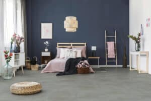 Ein modernes Schlafzimmer mit stilvoller Einrichtung und einem Bodenbelag in authentischer Beton- bzw. Steinoptik von Project Floors.