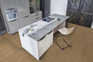 Eine moderne Wohnküche mit großzügiger Kücheninsel, stilvollem Designmix und hochwertigem Parkettboden von Project Floors.