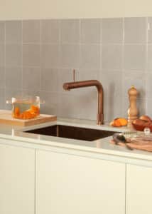 Ein “Quooker Flex Square”-Wasserhahn in Rosé‑Kupfer in einer hellgrau‑beigen Küche von Quooker.
