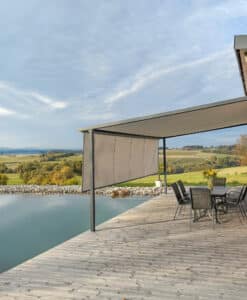 Terrasse bzw. Holzsteg am einem Schwimmteich mit einer Pergola mit schwarzem Alu-Rahmen mit beiger bzw. grauer Markise mit Verlängerung zur Senkrechtmarkise von Sonnenschutz Rachbauer.