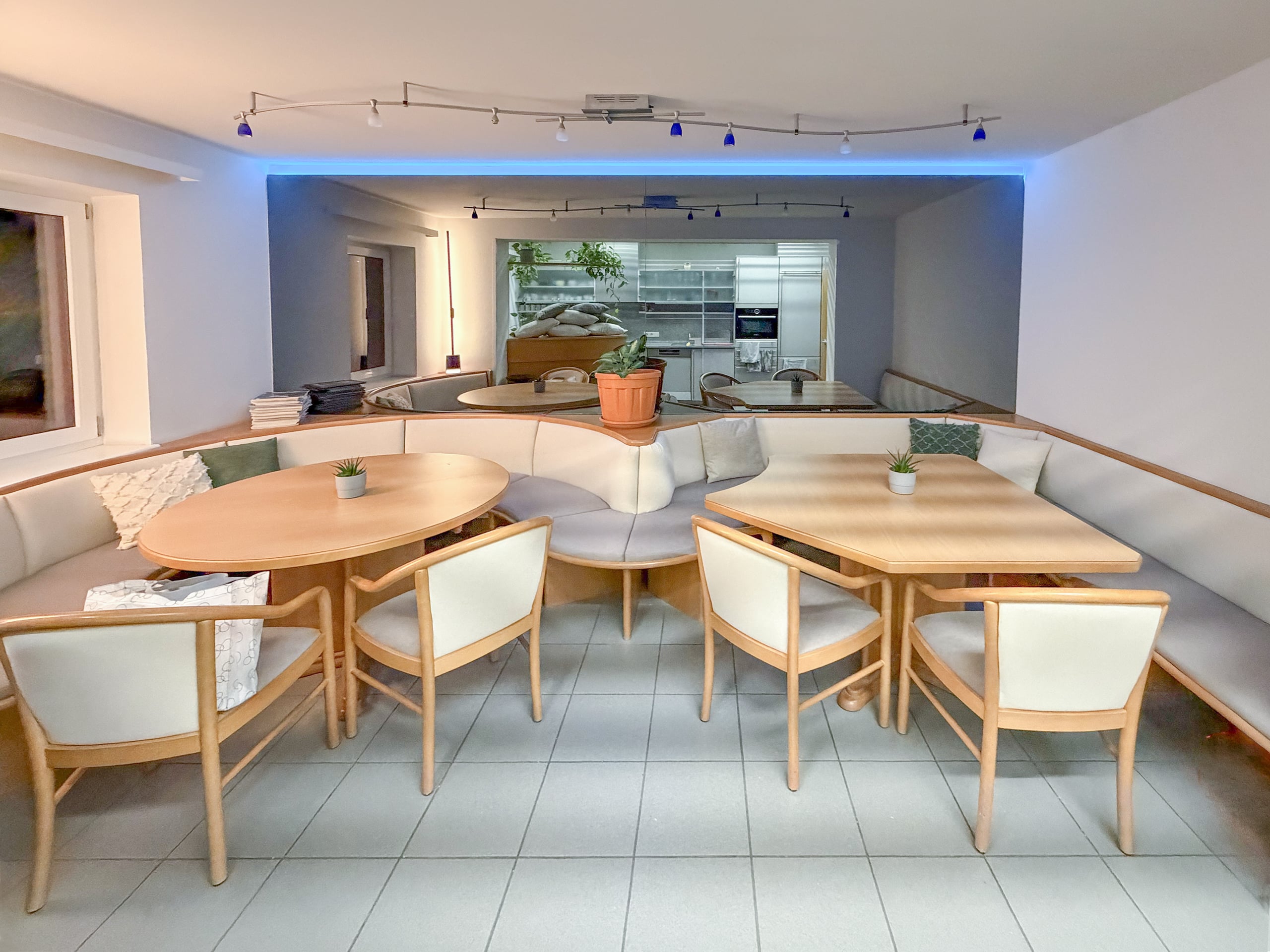 Gruppensitzbank und Polsterstühle mit neuer Polsterung in hellgrau und beigem Stoff, sauber verarbeitet von Raumgestaltung Gruber.