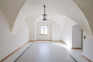 RÖFIX zeigt einen renovierten Innenraum mit Gewölbe, Fliesenboden und weißem Anstrich.