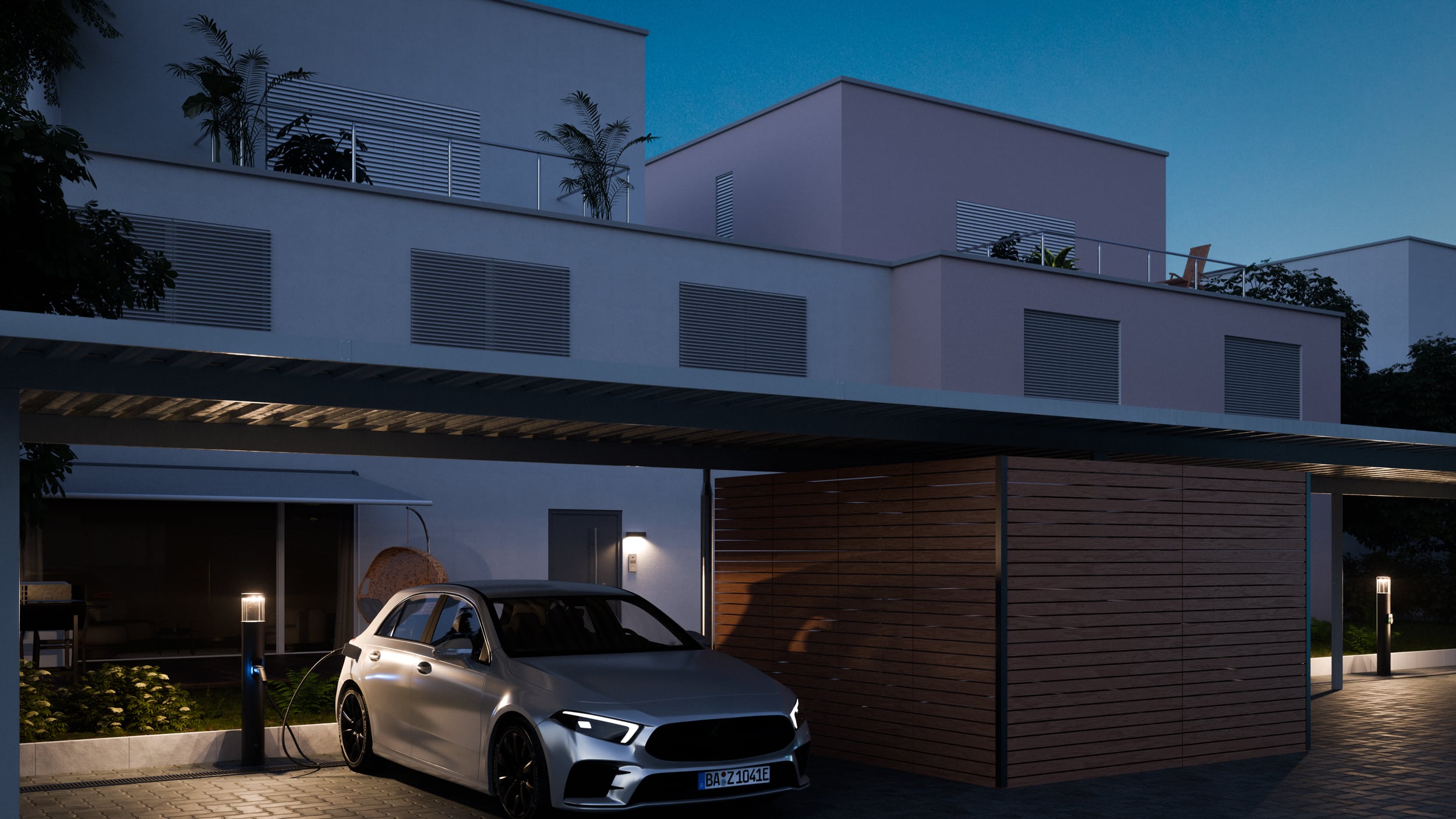 Reihenhäuser mit Carports und Licht-/Ladesäulen von RZB Energy bei Nacht.