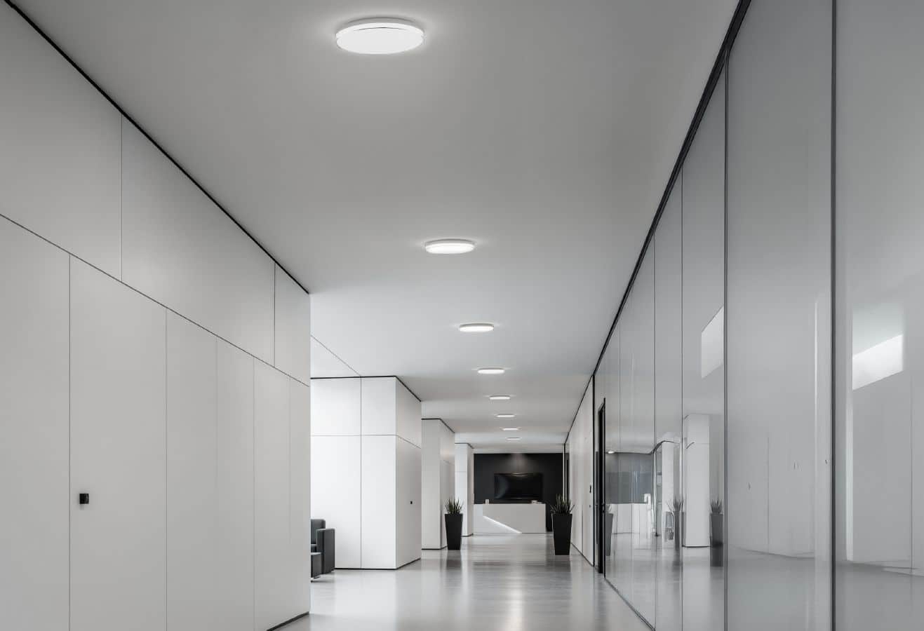 Ein Flur mit Wartebereich in einem Bürogebäude, das mit Deckenleuchten von RZB ausgestattet ist.