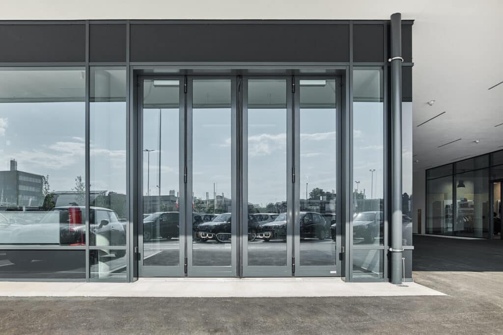 SCHNEIDER Torsysteme zeigt ein Autohaus mit einem gewerblichen voll-verglasten Falttore in anthrazit von außen.