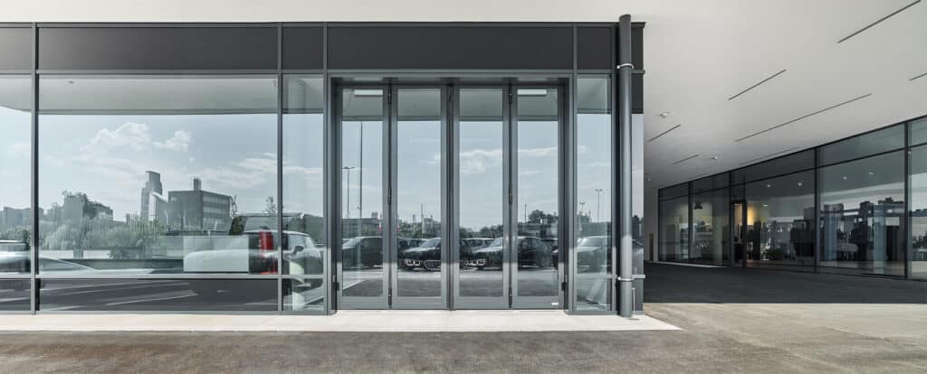 SCHNEIDER Torsysteme zeigt ein Autohaus mit einem gewerblichen voll-verglasten Falttore in anthrazit von außen.