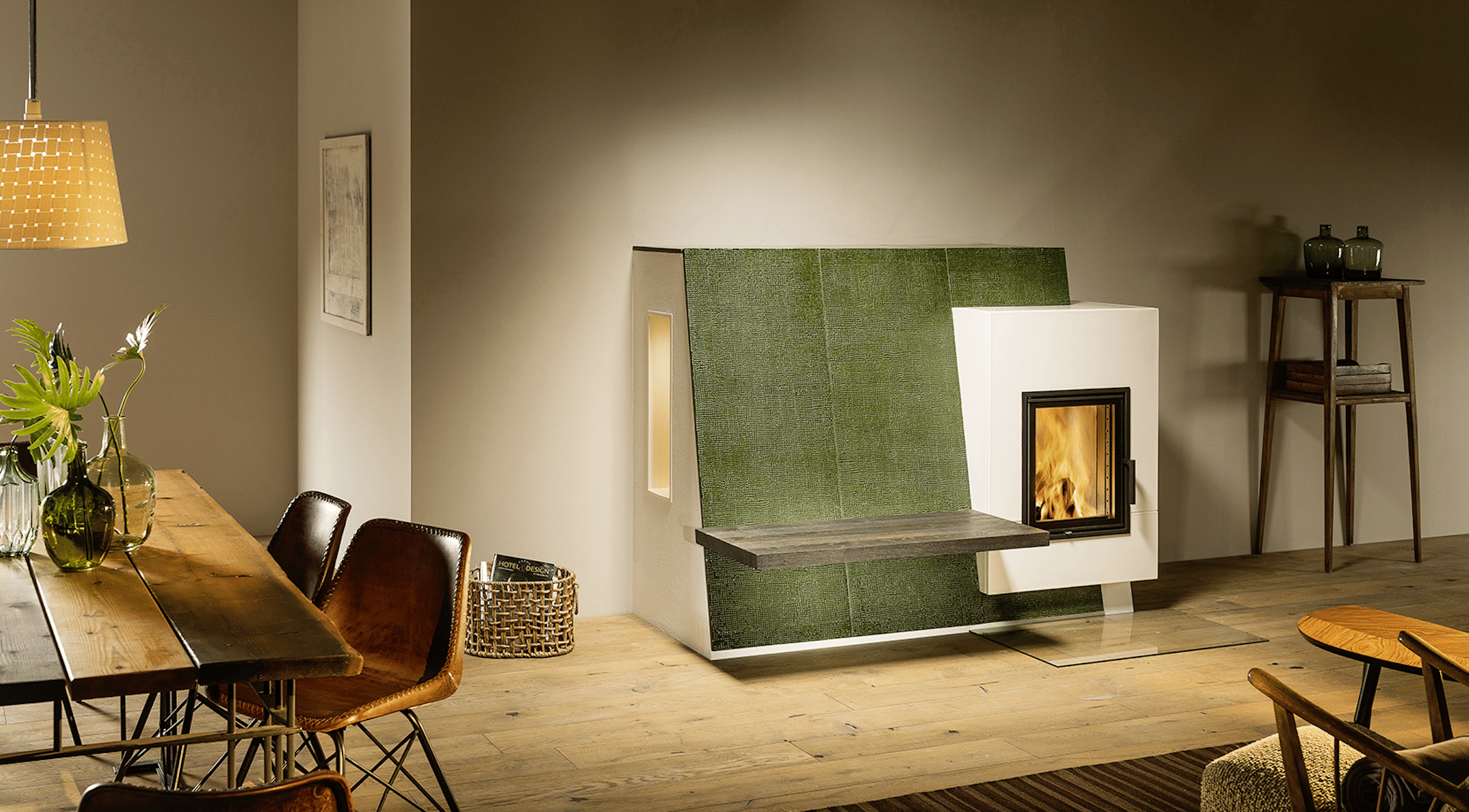 Sigmund zeigt einen modernen Sommerhuber Kachelofen mit großen, grünen Kacheln.