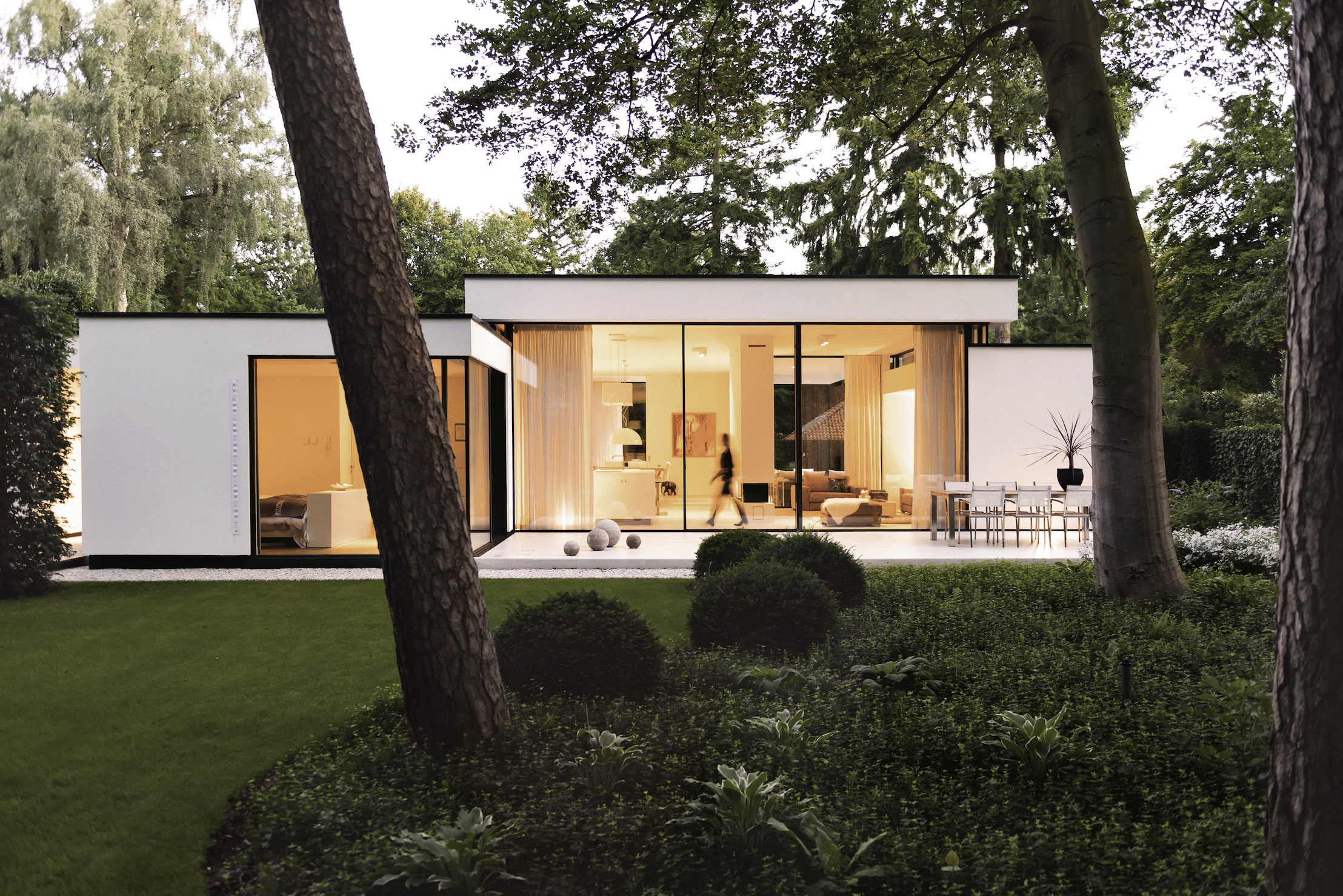 Weißer Bungalow mit Terrasse und deckenhohen Glas-Schiebetüren von Solarlux.