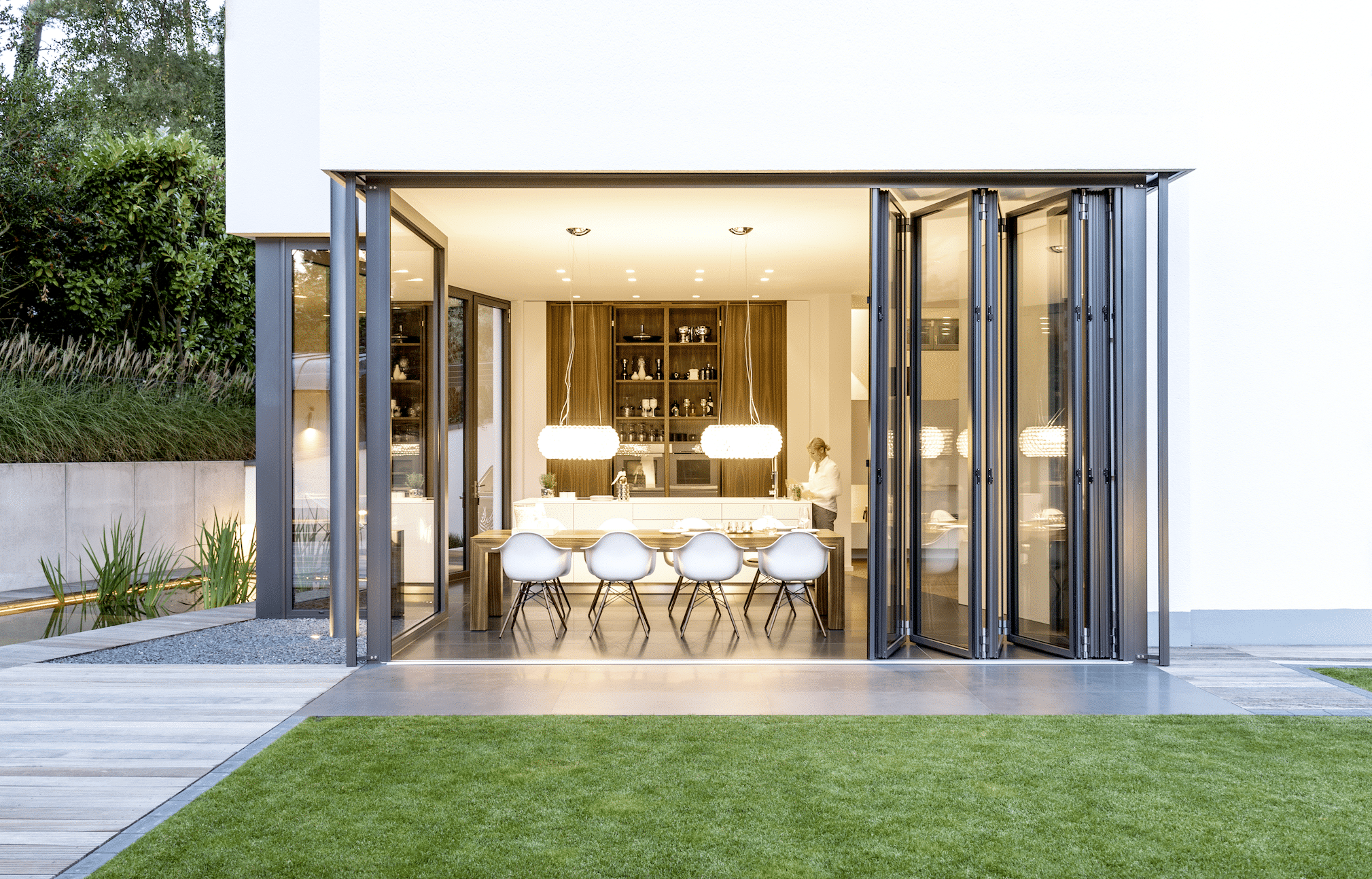 Glas-Falttüren von Solarlux geben den Blick auf den eleganten Essbereich des Hauses frei.