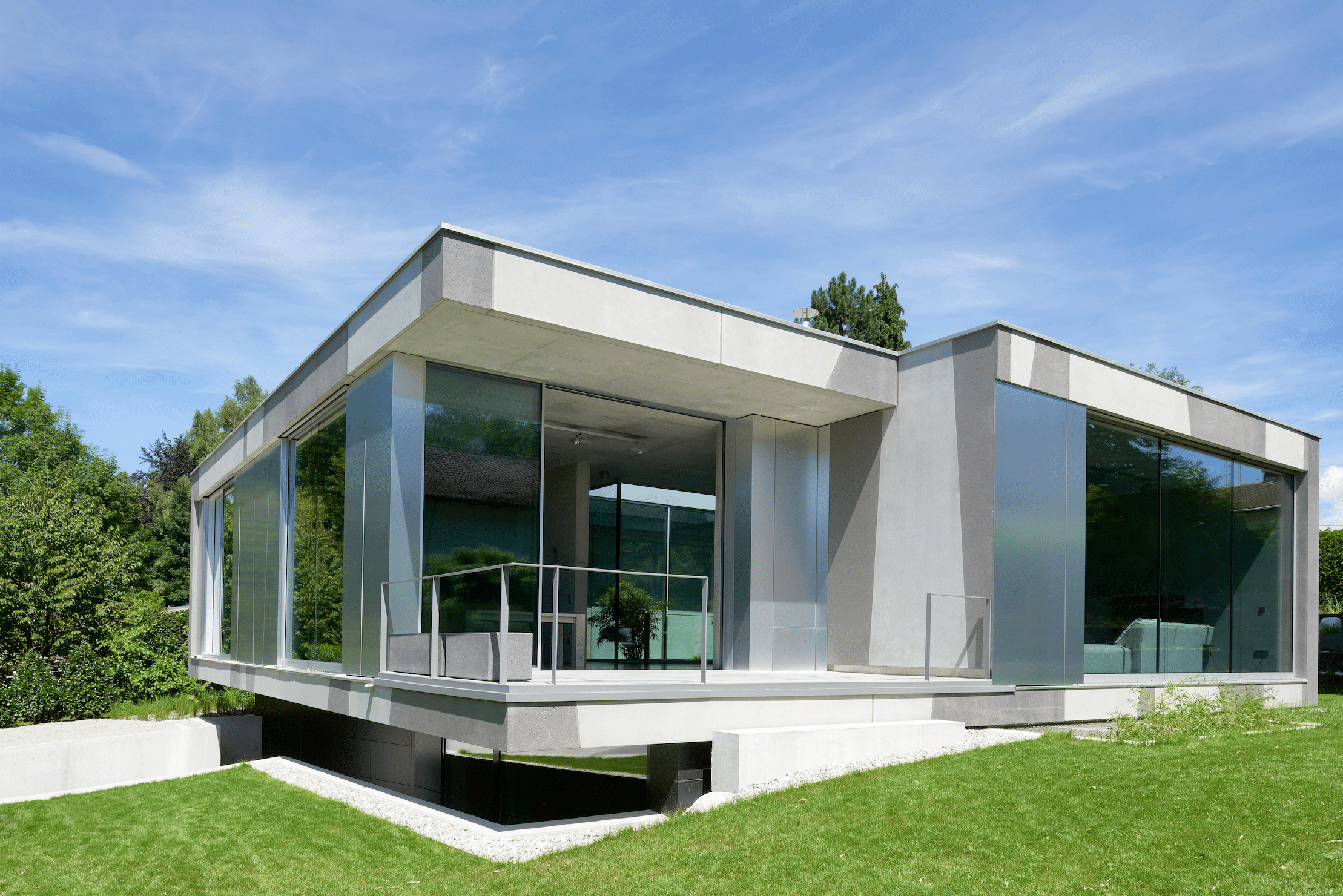 Weißer Bungalow mit Terrasse und deckenhohen Glas-Schiebetüren von Solarlux.