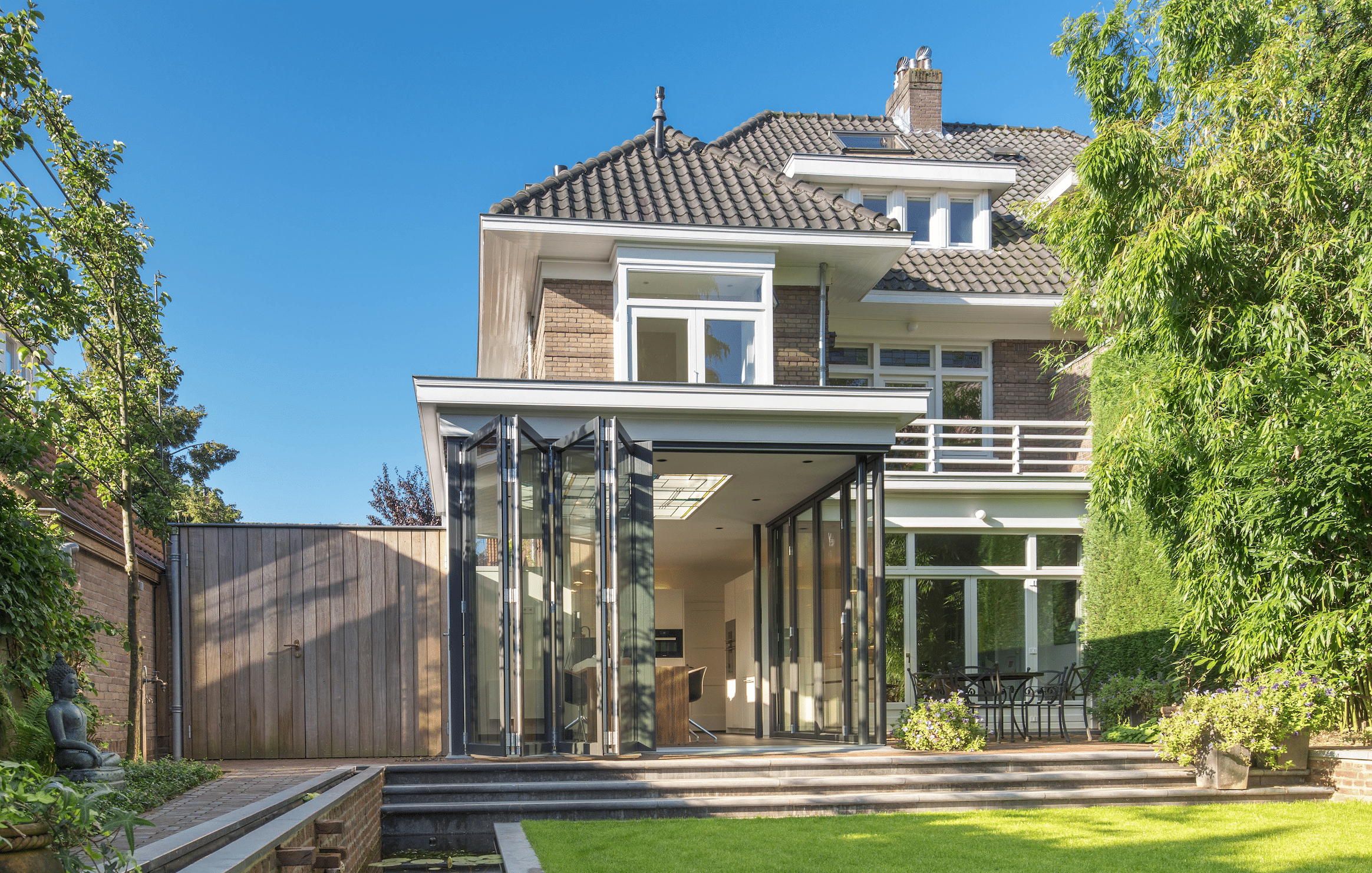 Wohnhaus mit Wintergarten-Zubau mit deckenhohen Glas-Falt-Schiebetüren von Solarlux.