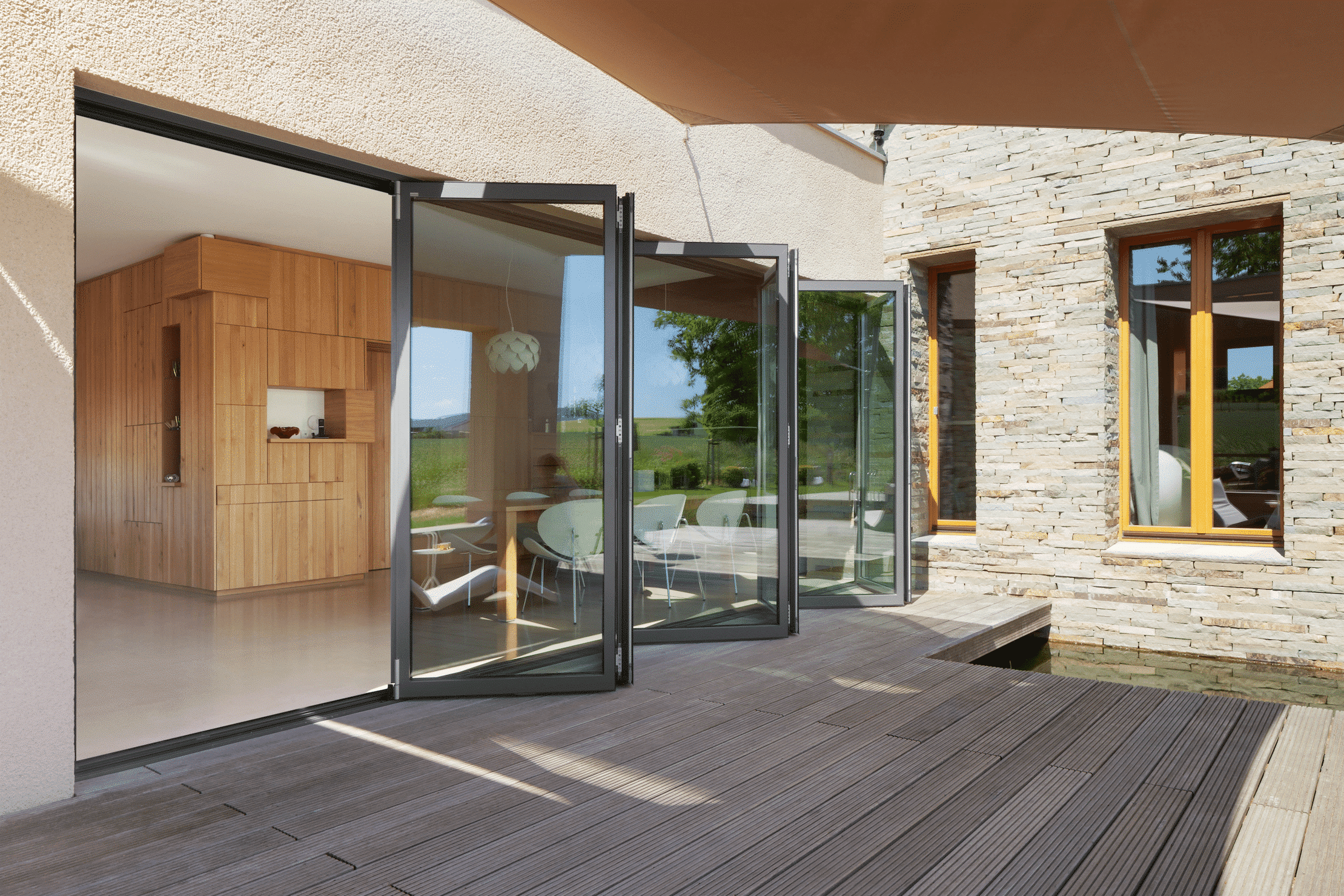 Wohnhaus mit Terrasse und deckenhohen Glas-Falt-Schiebetüren von Solarlux.