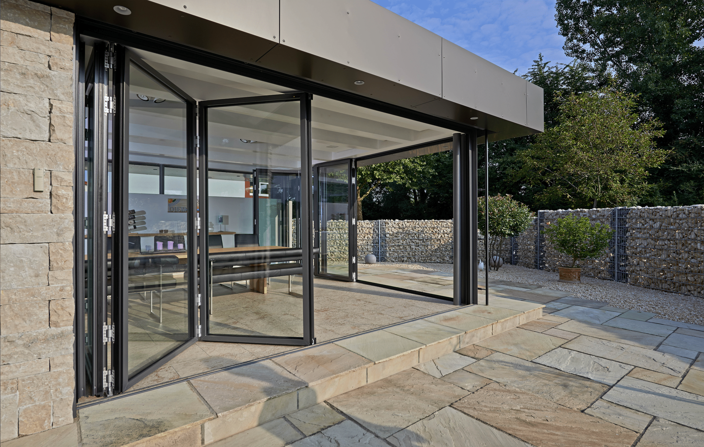 Wohnhaus mit Terrasse und deckenhohen Glas-Falt-Schiebetüren von Solarlux.