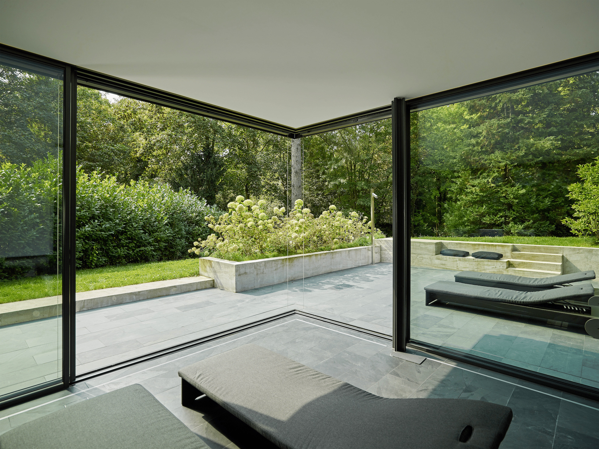 Wellnessbereich mit Terrasse und deckenhohen Glas-Schiebetüren von Solarlux.