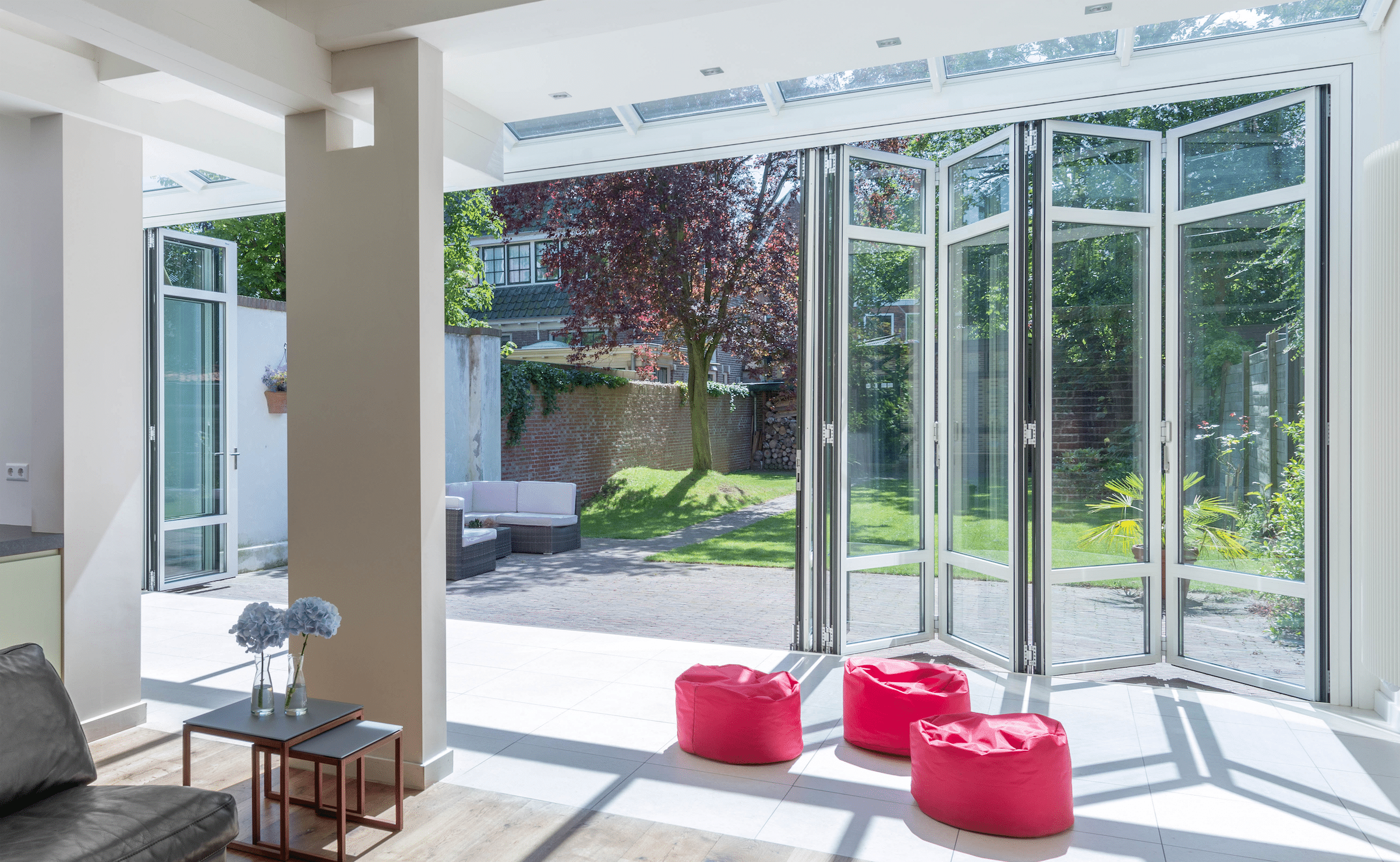 Heller Wohnbereich mit Terrasse und deckenhohen Glas-Falt-Schiebetüren von Solarlux.