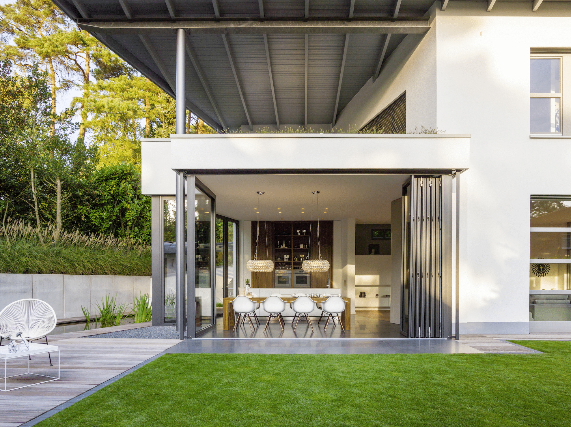 Wohnhaus mit Terrasse und deckenhohen Glas-Falt-Schiebetüren von Solarlux.